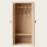 Rosa Schrank mit drei Kleiderbügeln